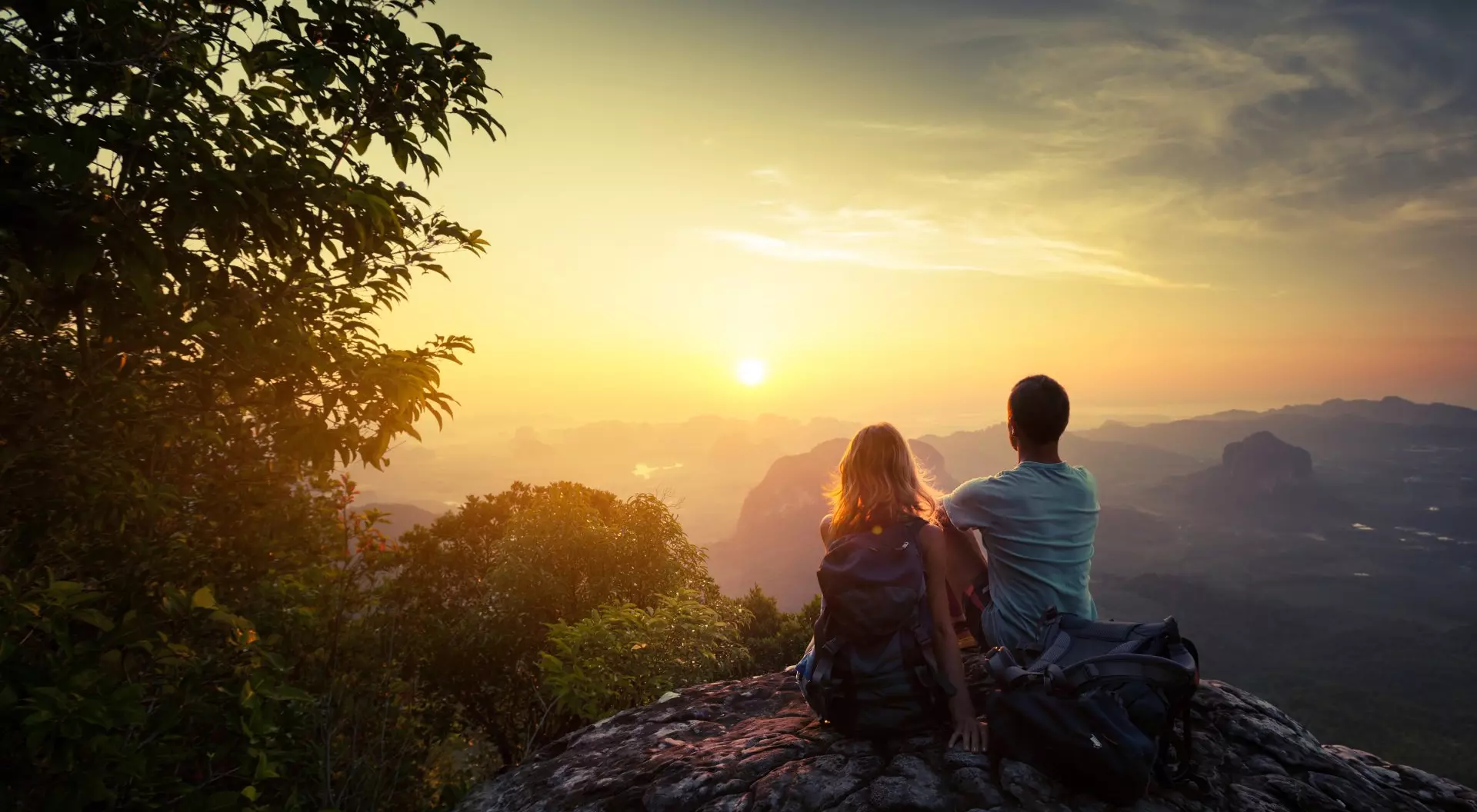 South America Two hikers on top of the mountain enjoying sunrise over the tropical valley
