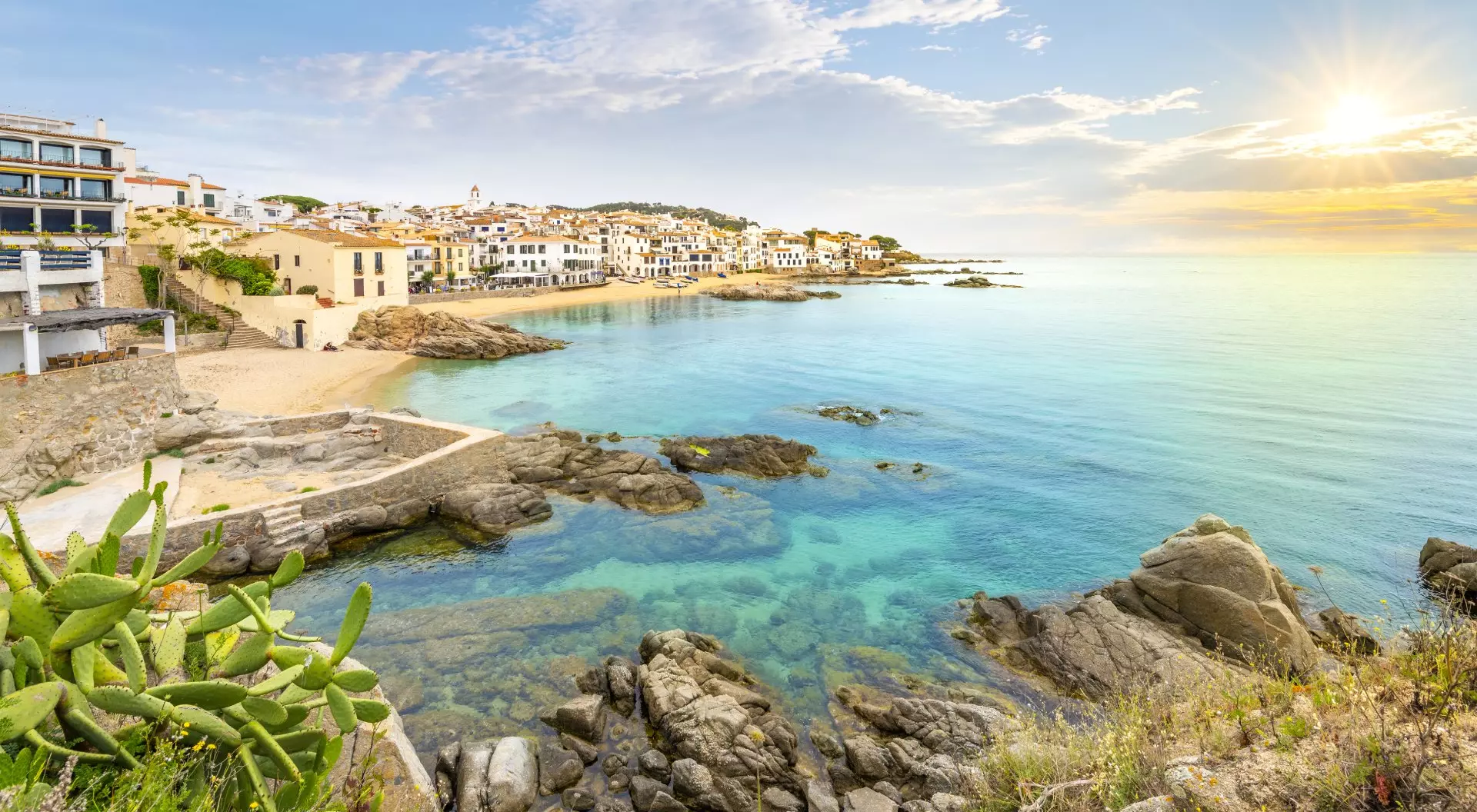 View of the sandy beach, rocky coastline and whitewashed town