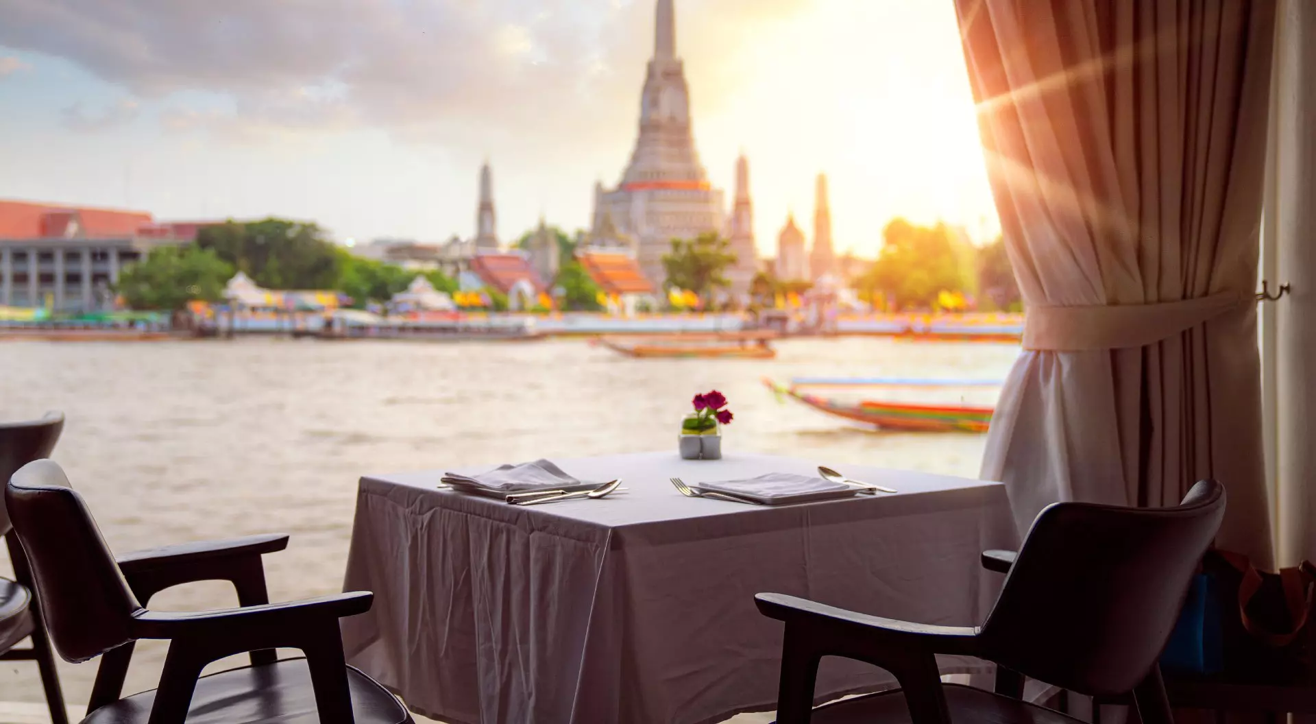 View of Wat Arun (Temple of Dawn), from riverside bar in Bangkok, Thailand