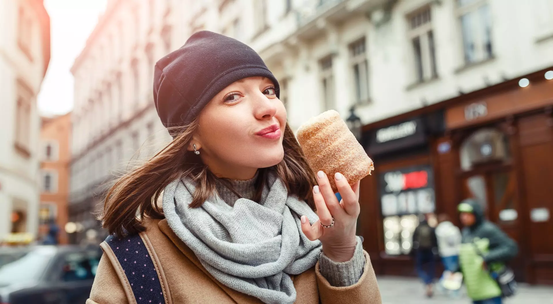 Prague, Czech Republic Woman eats trdelnik at a street market in Prague, Czech Republic
