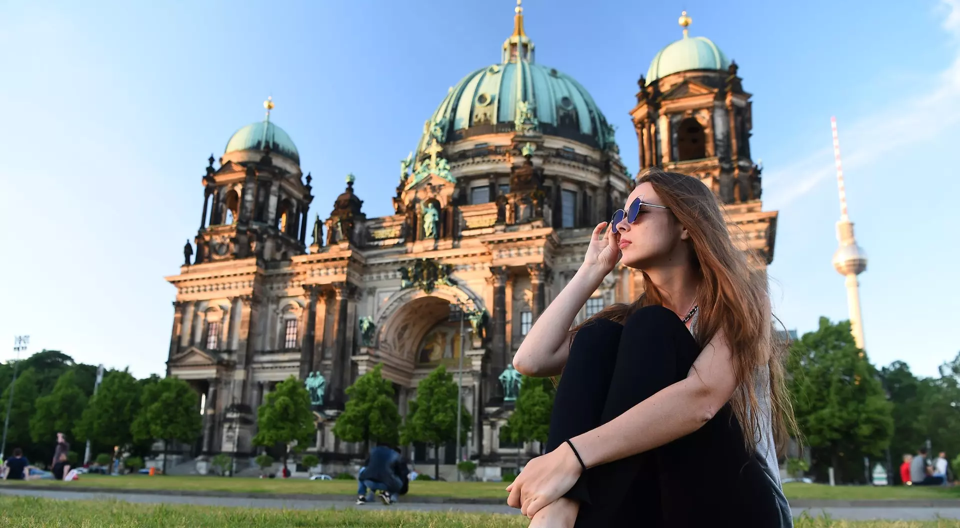 Berlin, Germany Woman sitting in front of Berlin Cathedral at beautiful sunset, Berlin, Germany