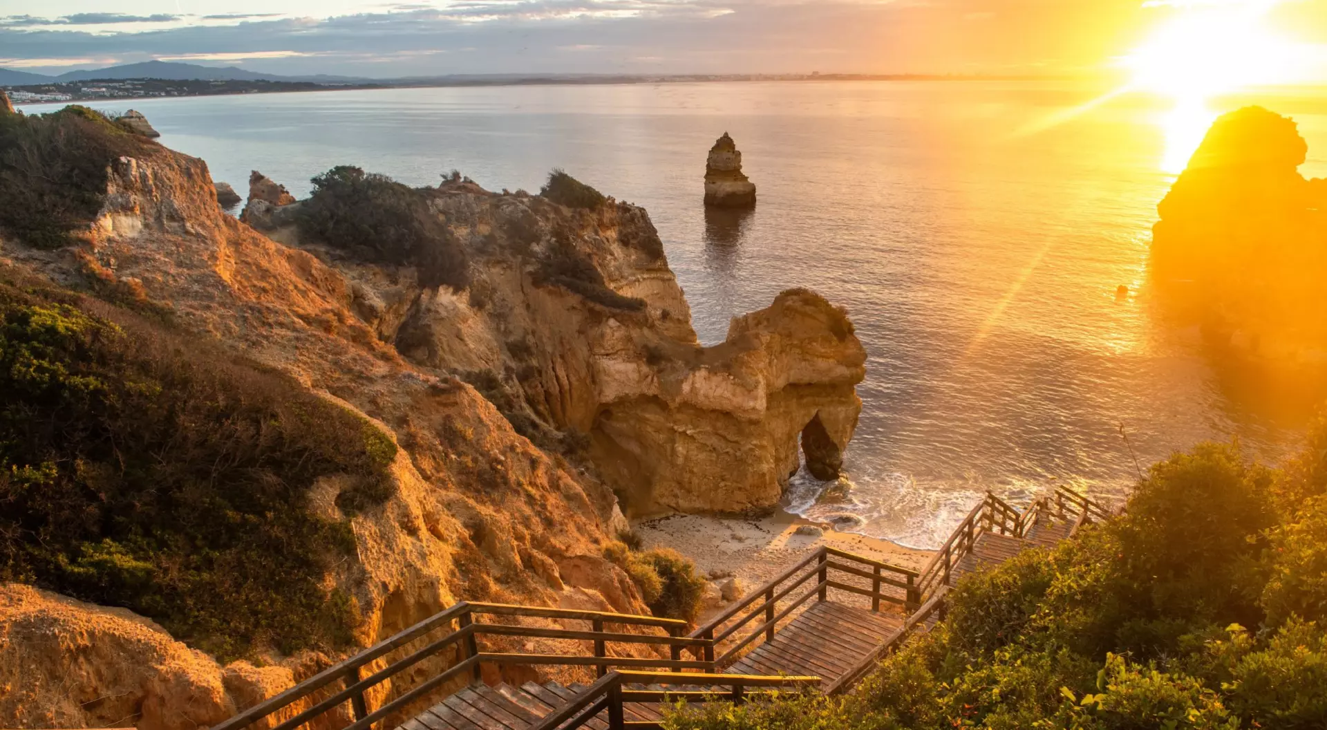 Algarve, Portugal Wooden footbridge to beautiful beach Praia do Camilo near Lagos in Portugal at sunrise