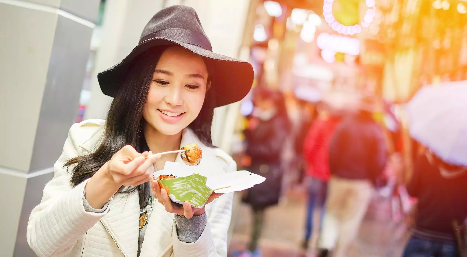 Hong Kong Young Asian Woman Eating Dumpling Batter (Takoyaki) on Street in Hong Kong