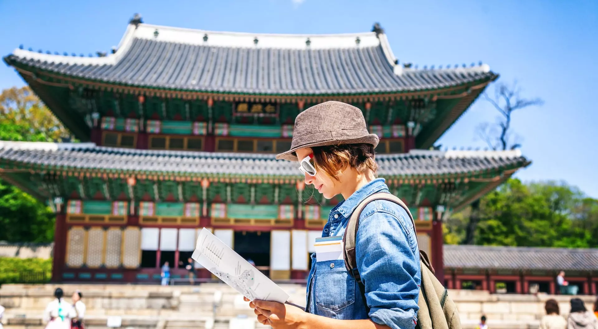 Young woman tourist with map in hand with Asian architecture, Seoul, South Korea