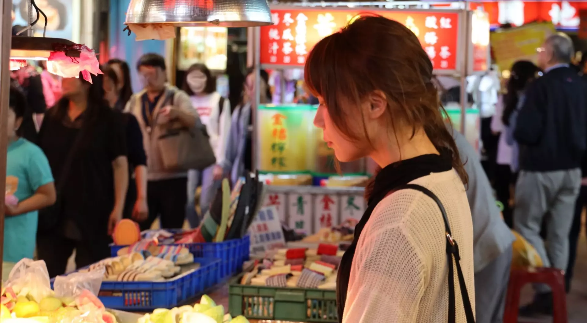 Young woman walking at night market 