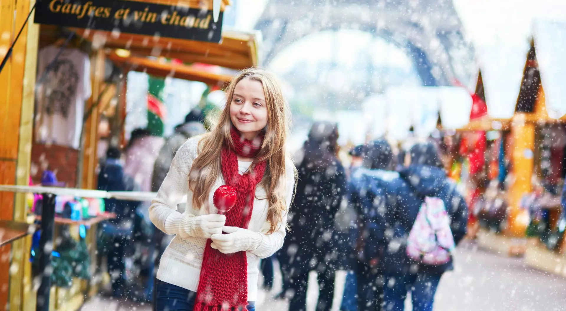 Paris, France Young girl with caramel apple at a Parisian Christmas market and Eiffel Tower in background at winter, Paris, France