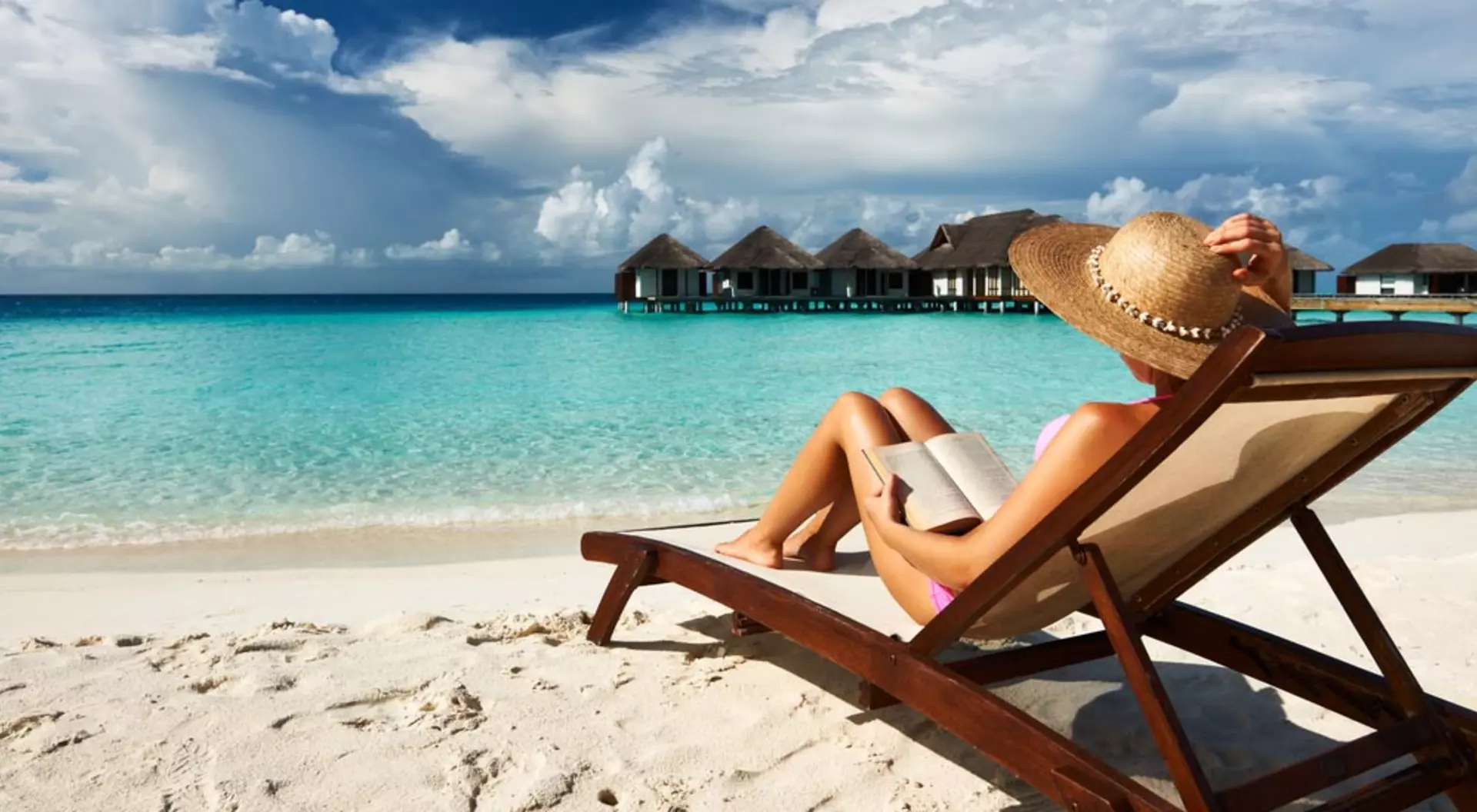 Young woman reading a book at the beach