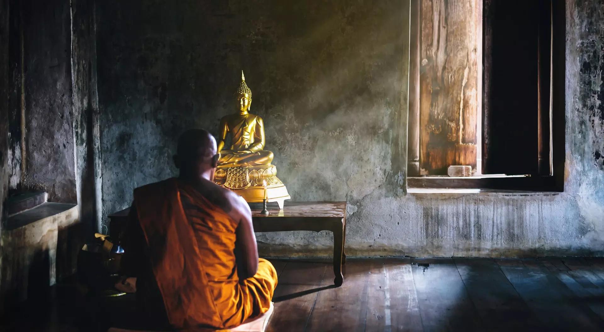 Thailand a Buddhist monk meditates in front of a statue of the Buddha in Thailand