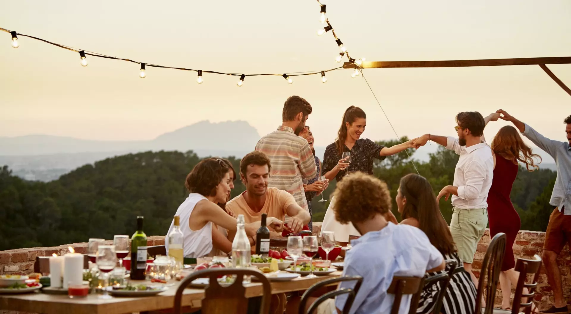 Spain a group of travellers enjoying a meal and dancing while on a terrace in Spain