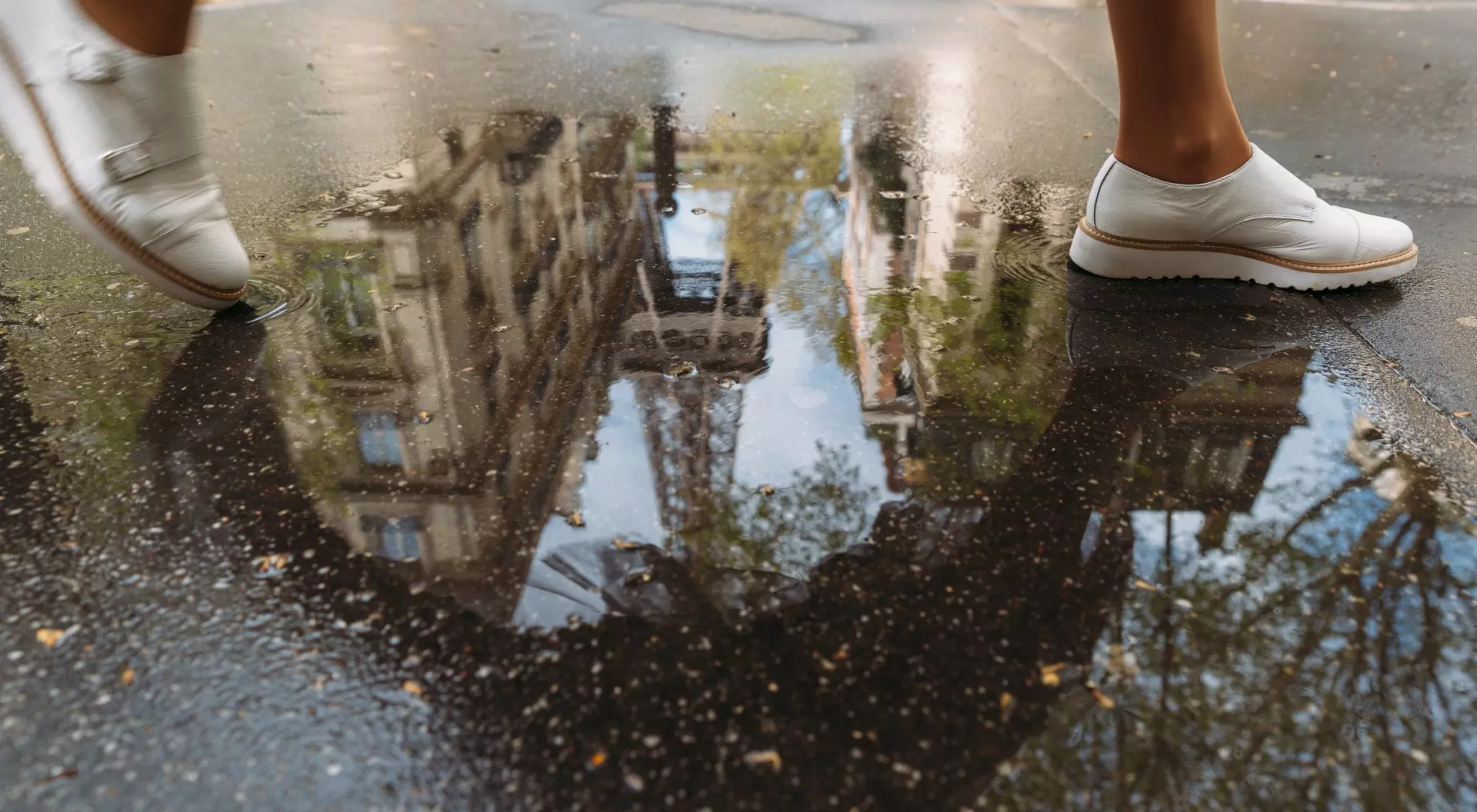 a woman walks through a puddle reflecting the Eiffel Tower on a trip to Paris, France