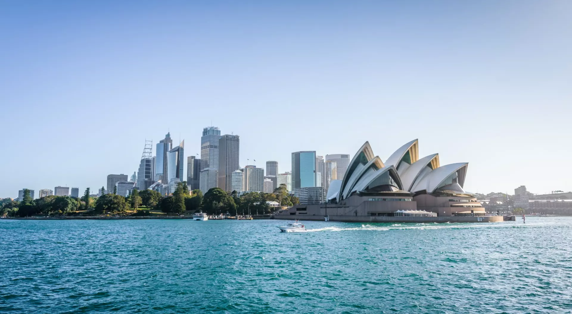 view of opera house and buildings in harbour with blue sky