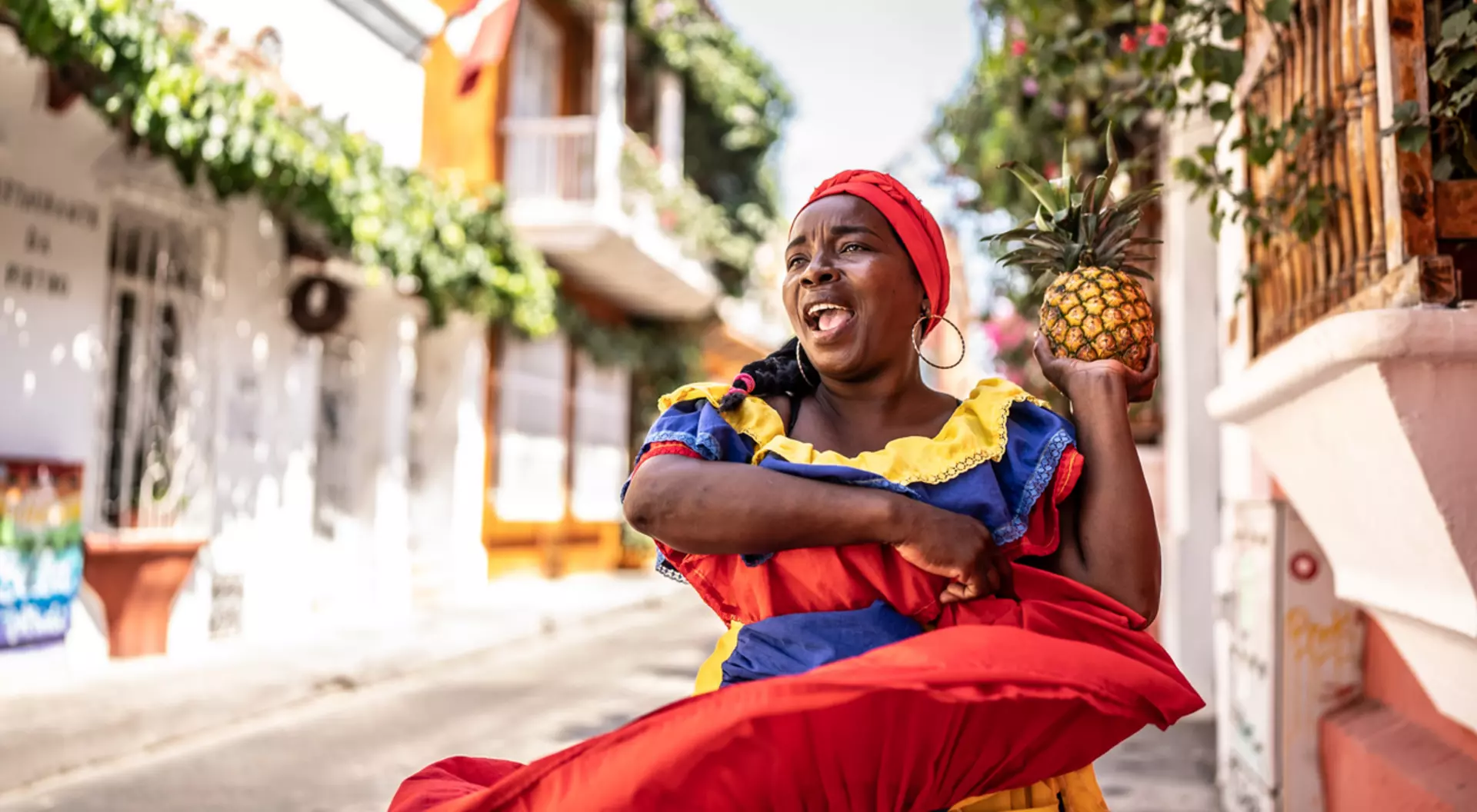 A palenquera dances in her colourful dress in the streets of Cartagena in Colombia