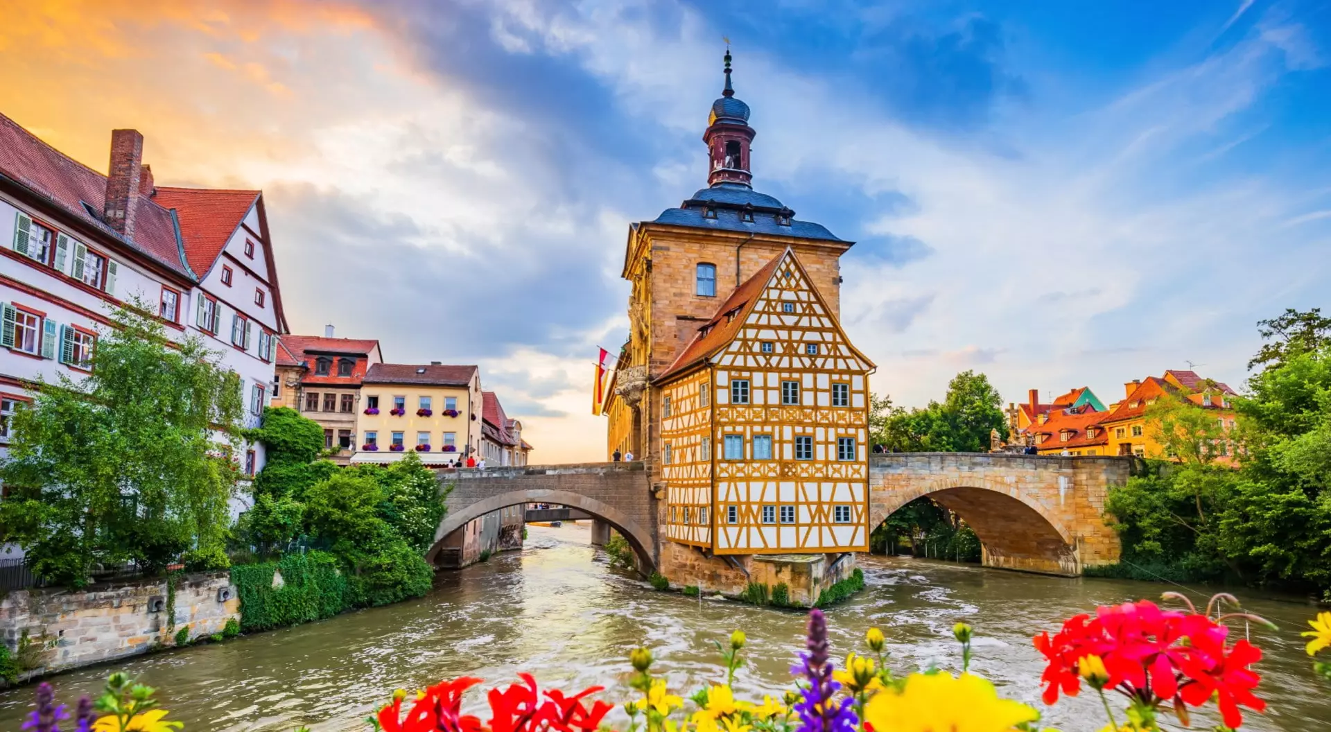 A traditional tower and bridge across a river in the colourful old town of Bamberg, Germany.