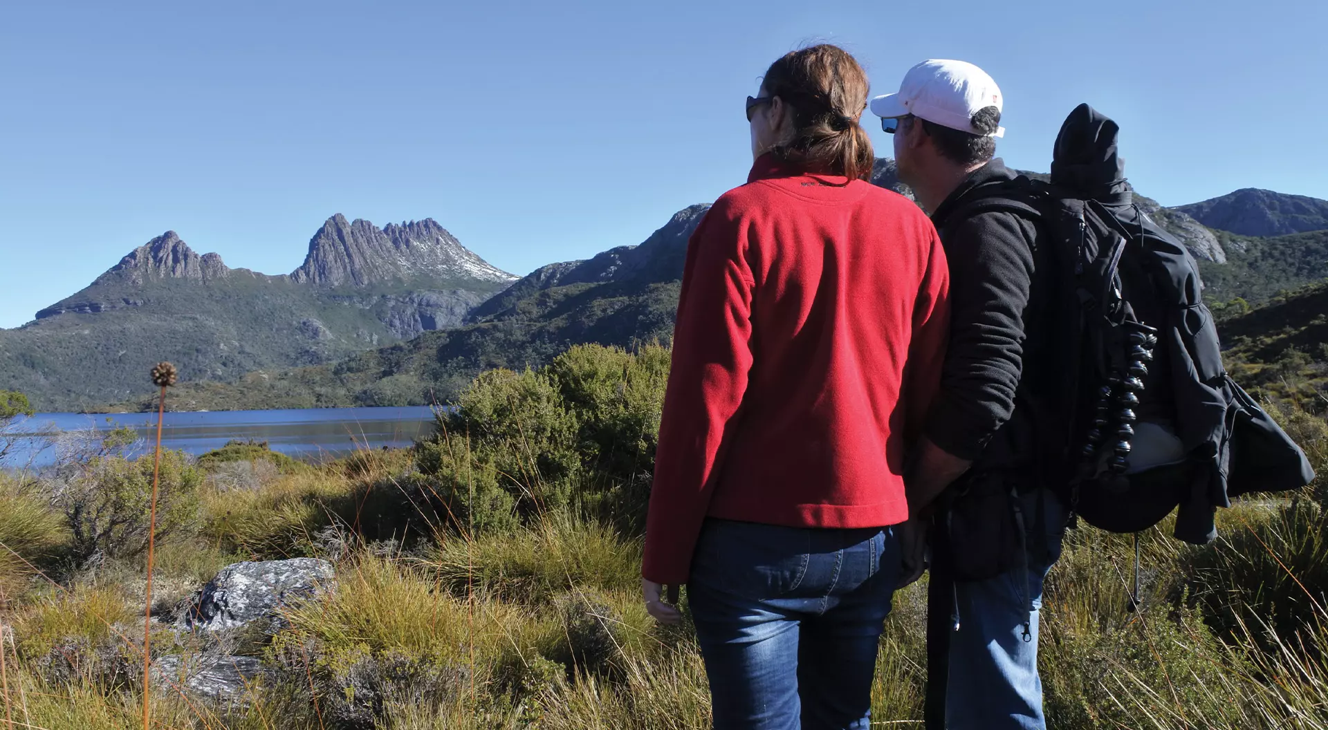 couple looking at green hills on hiking trail