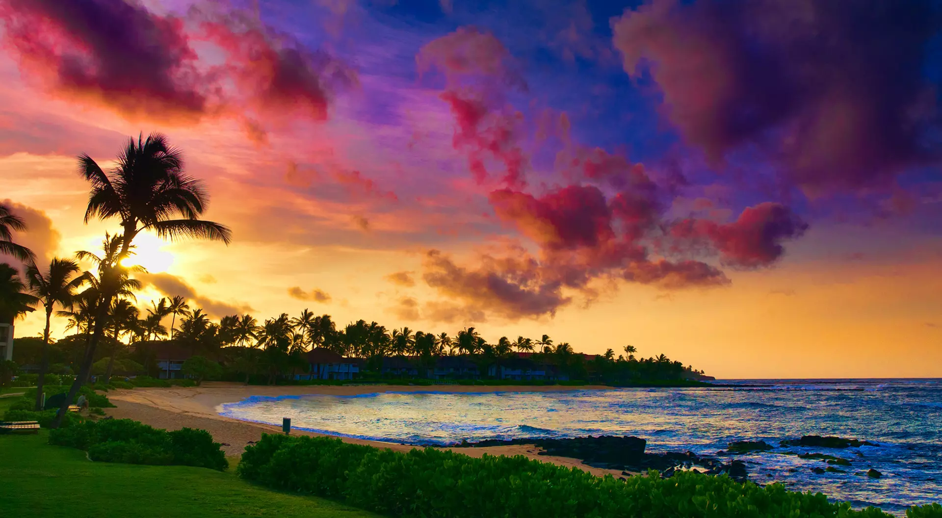 Hawaii A person standing on a beach in Hawaii during sunset