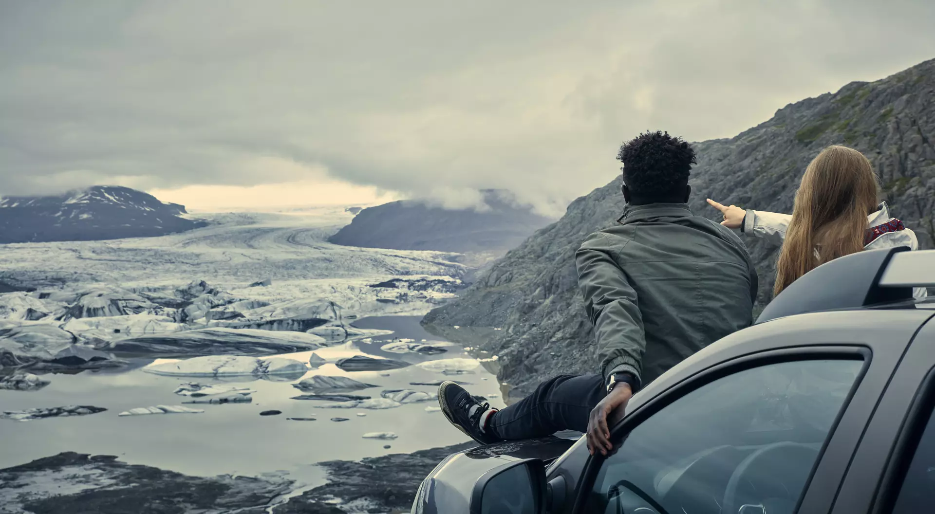 Iceland Couple relaxing during road trip. Looking at view