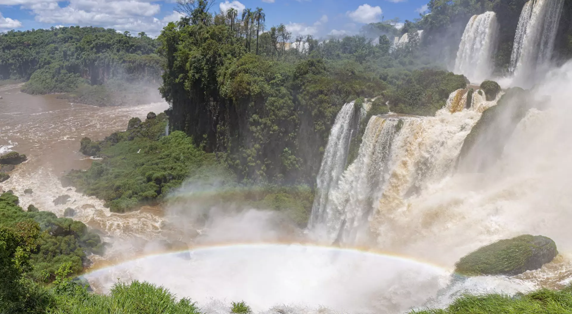 Iguassu Falls, Brazil Impressive Iguazu Falls with rainbow and blue sky with white clouds, Argentina