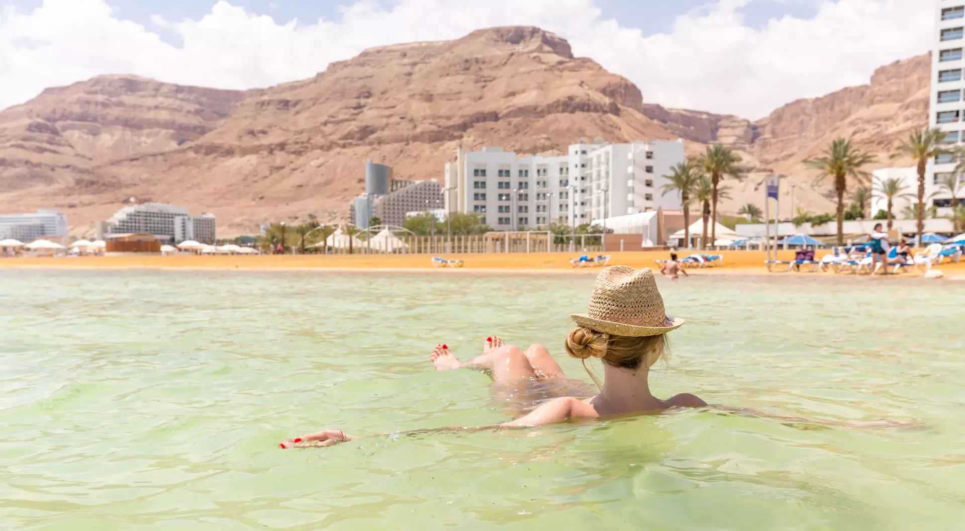 Israel Young beautiful tourist woman floating swimming salty water beach Dead sea, Ein Bokek, Israel travel.
