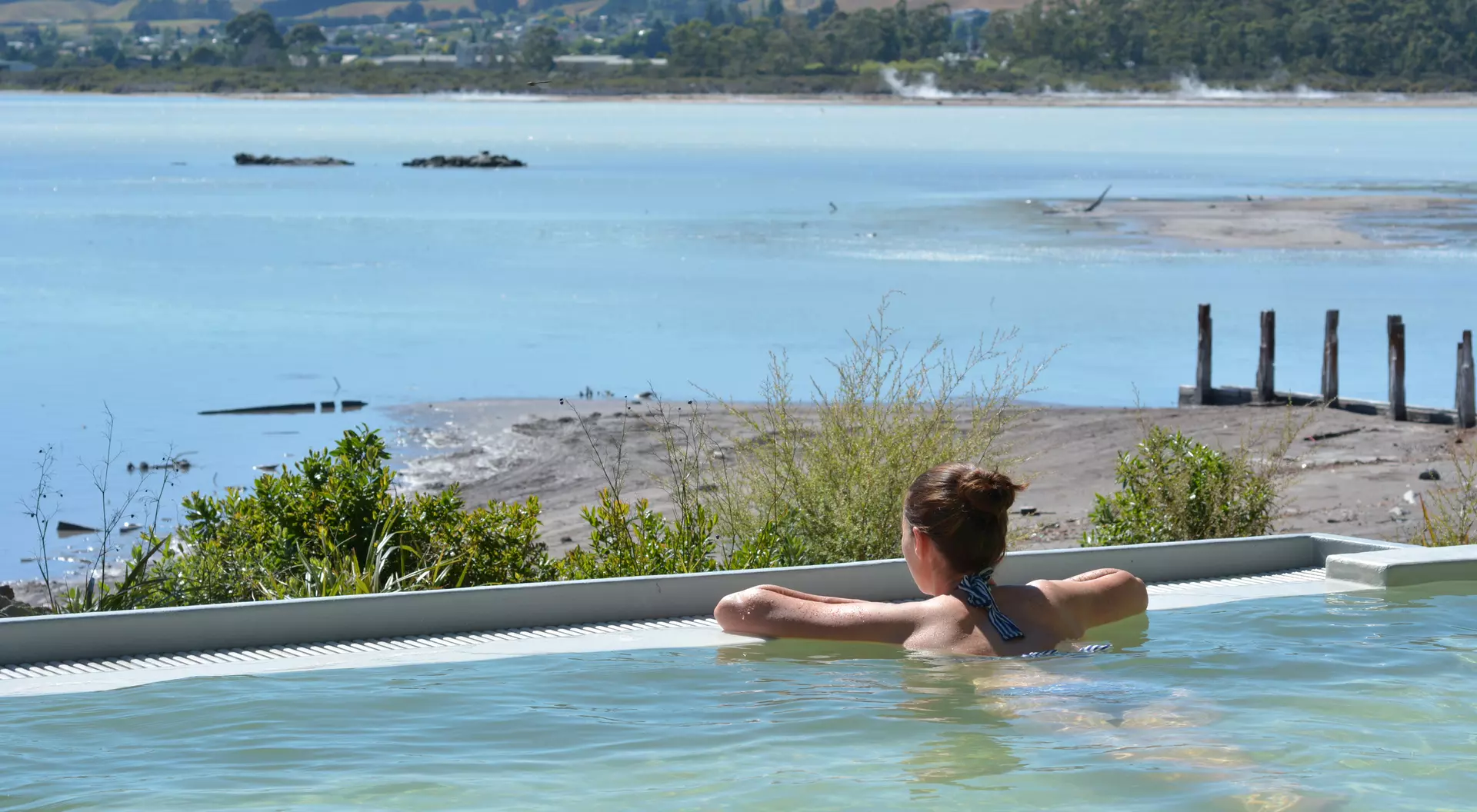 Young woman having a spa in outdoors hot pool in Rotorua, New Zealand.