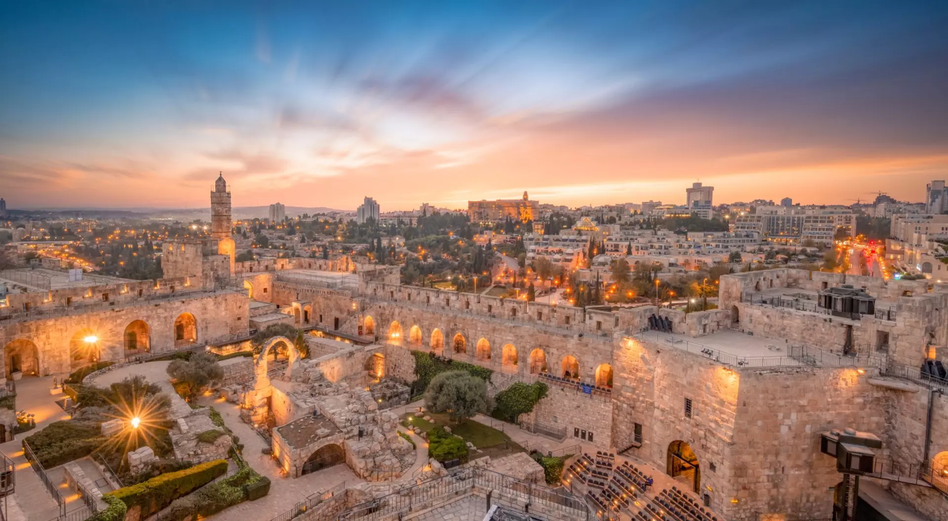 ruins and gardens set against a backdrop of a desert city