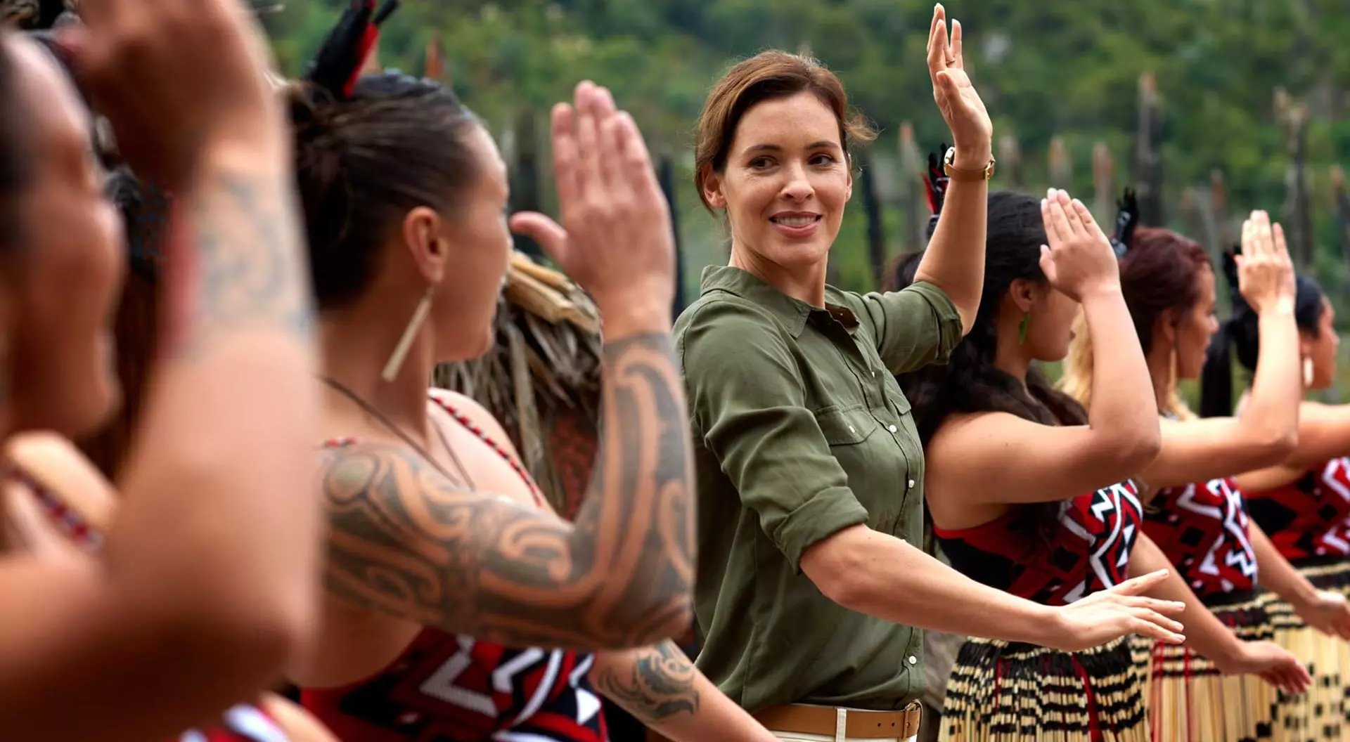 woman learning a dance alongside indigenous performers