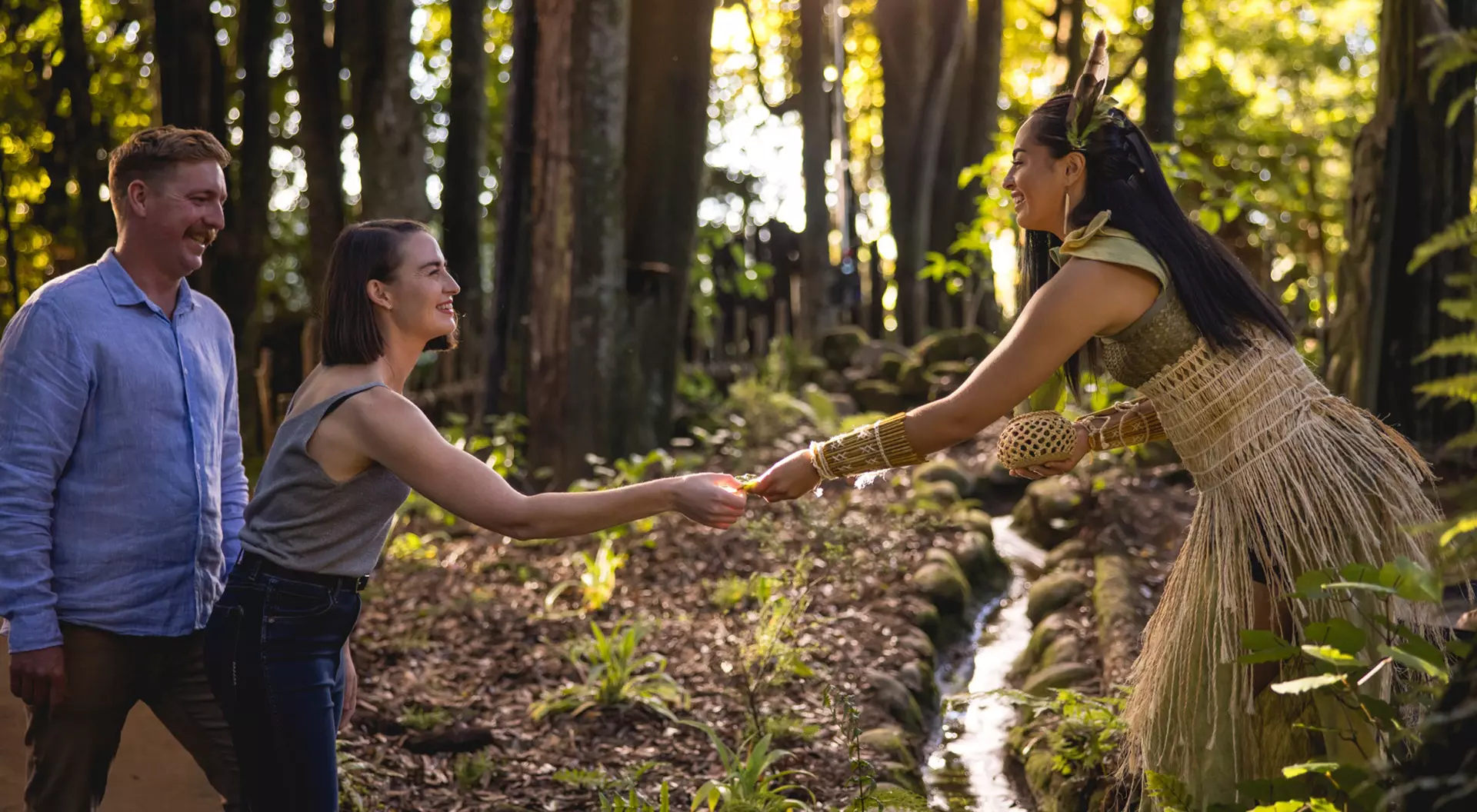 tourists meeting a Maori women in traditional dress in the forest