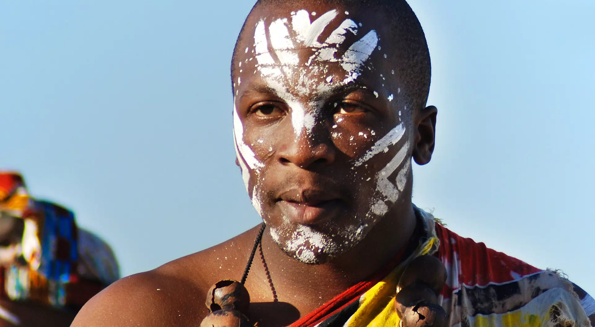 Young man wears traditional clothing during presentation of a Zulu show