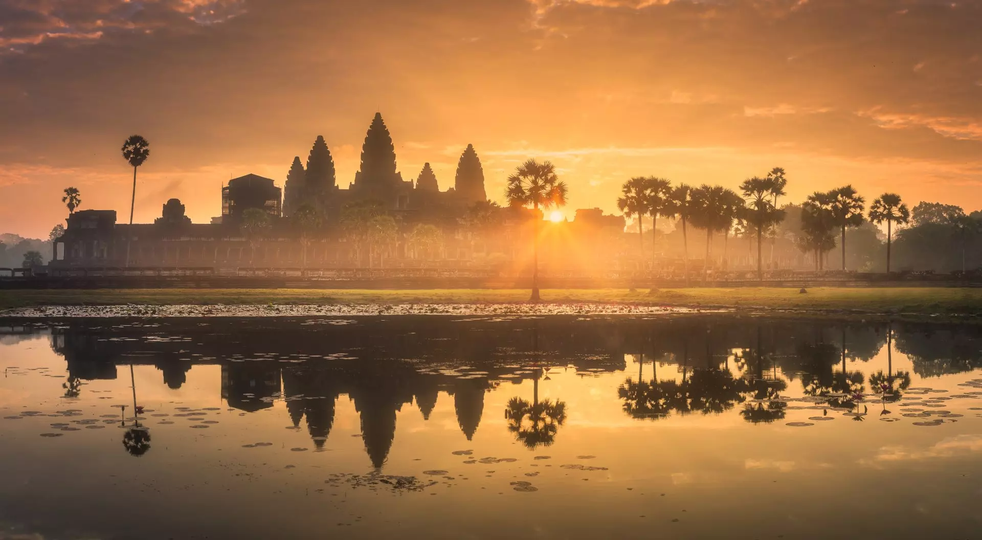 Angkor Wat, Cambodia sunrise over a temple with water reflecting in foreground