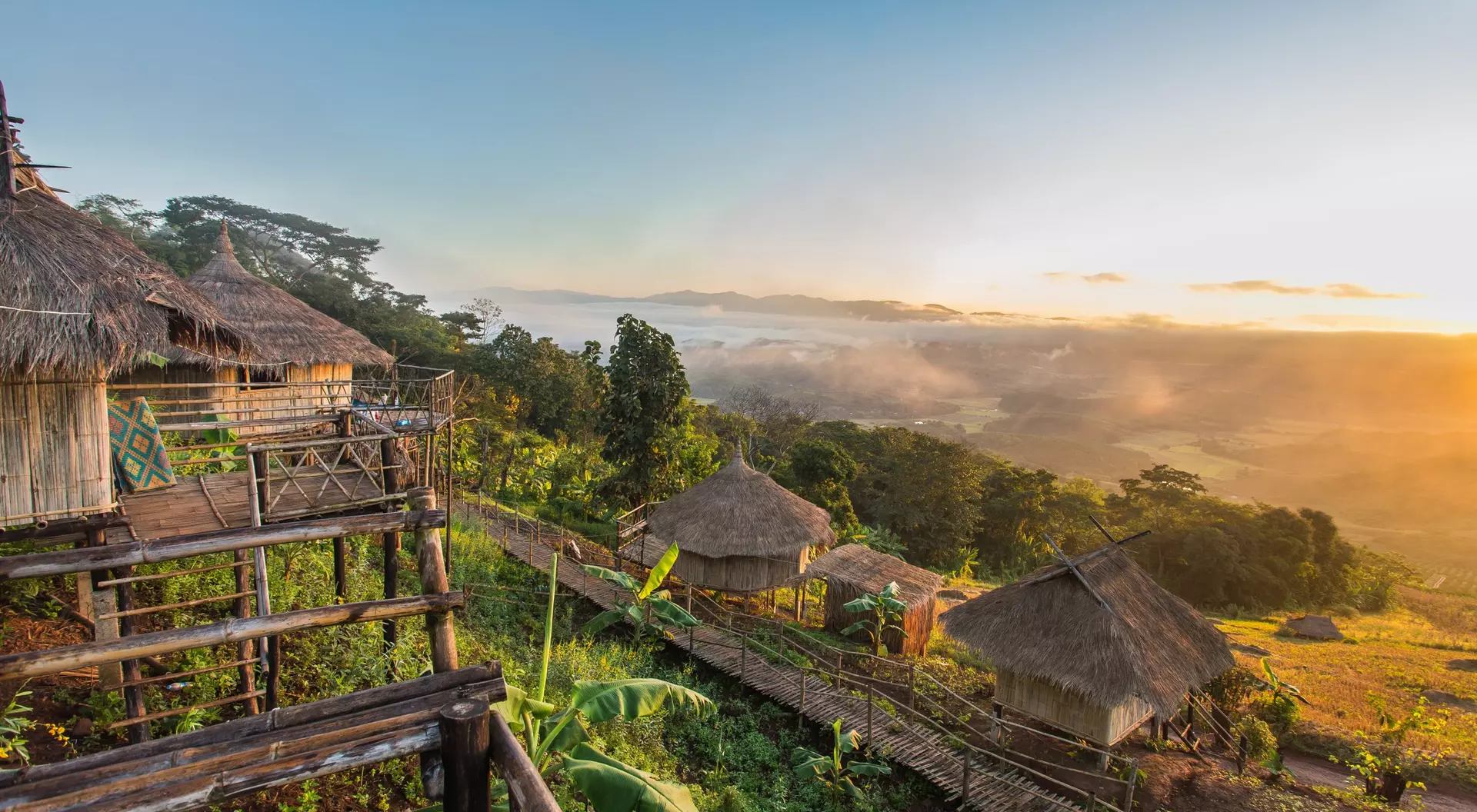 Chiang Rai, Thailand hilltop view of wooden buildings and countryside at dawn