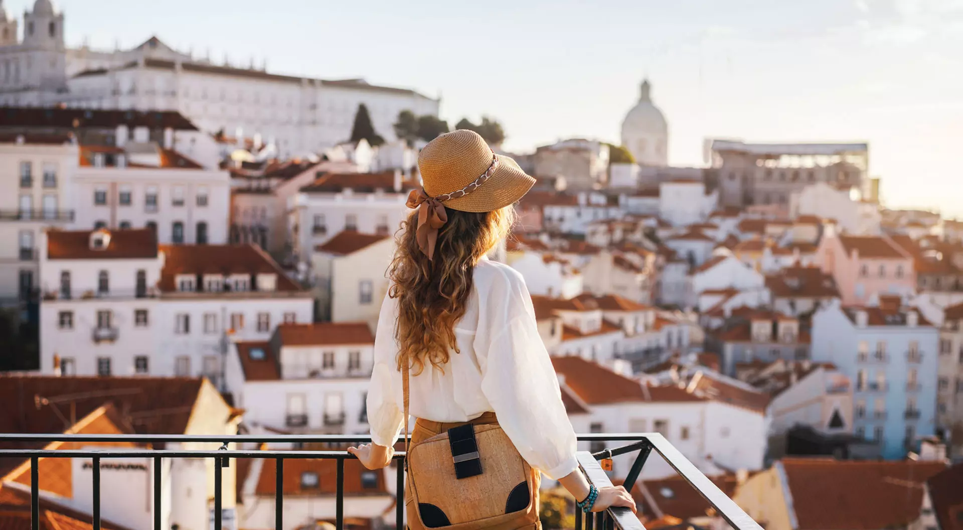 Lisbon, Portugal A woman stands looking out over the whitewashed homes of Lisbon, Portugal