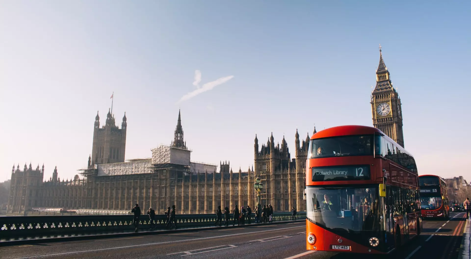London, England red double-decker bus passing Palace of Westminster, London during daytime