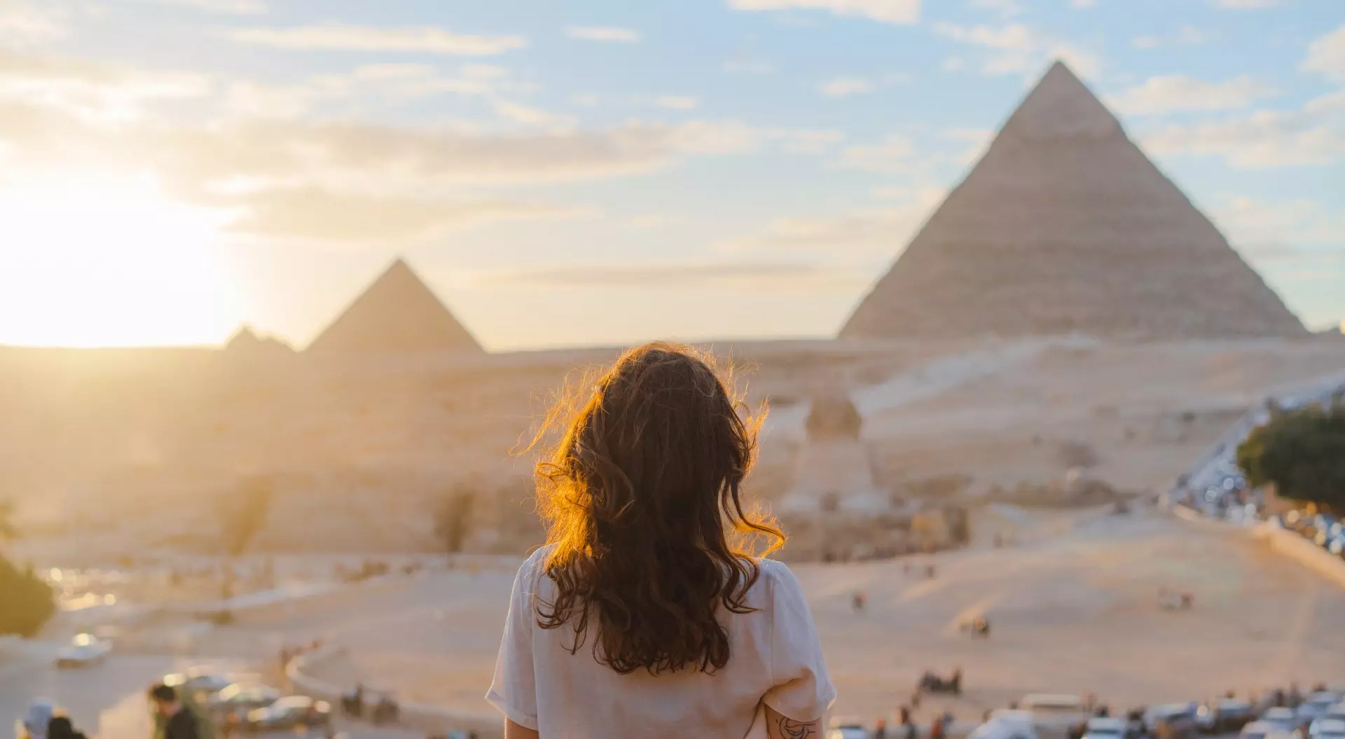 Giza, Egypt Woman standing on balcony overlooking the pyramids in the distance