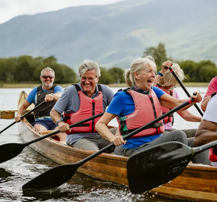 A senior group of tourists enjoying rowing on the River Derwent