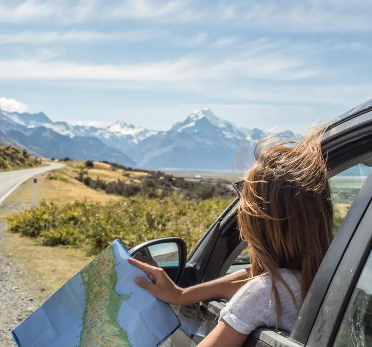 Woman in a car looking at a map for directions