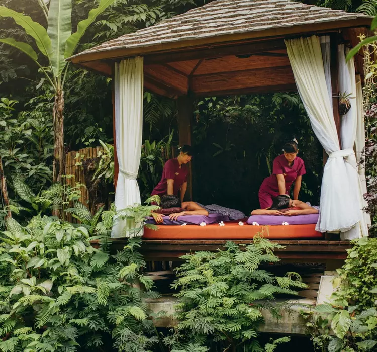A couple enjoy massages in an outdoor gazebo in the jungle