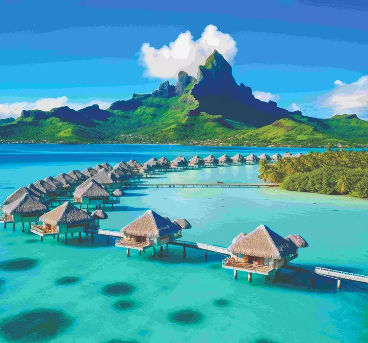 Overwater bungalows with mountain in background