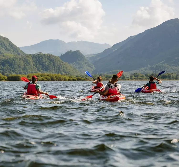 The Lake District in Cumbria Group learning to kayak across water on Derwent Water in The Lakes District in Cumbria