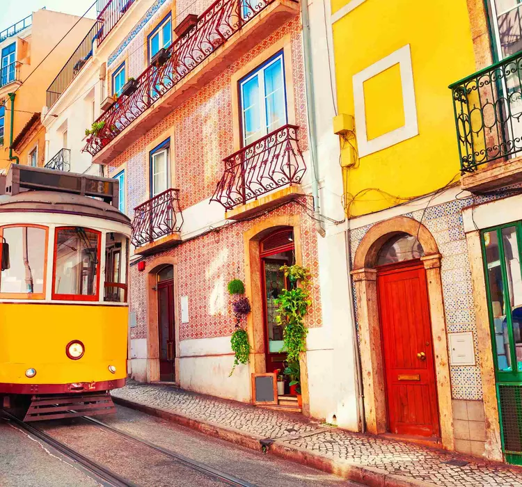 Yellow street tram on a colourful city street
