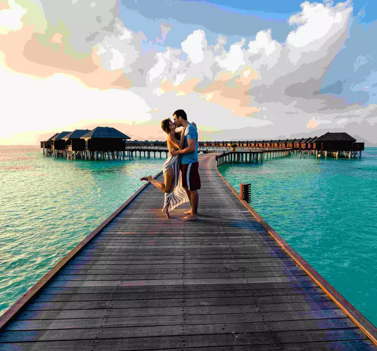 Couple embracing on an overwater boardwalk over the ocean