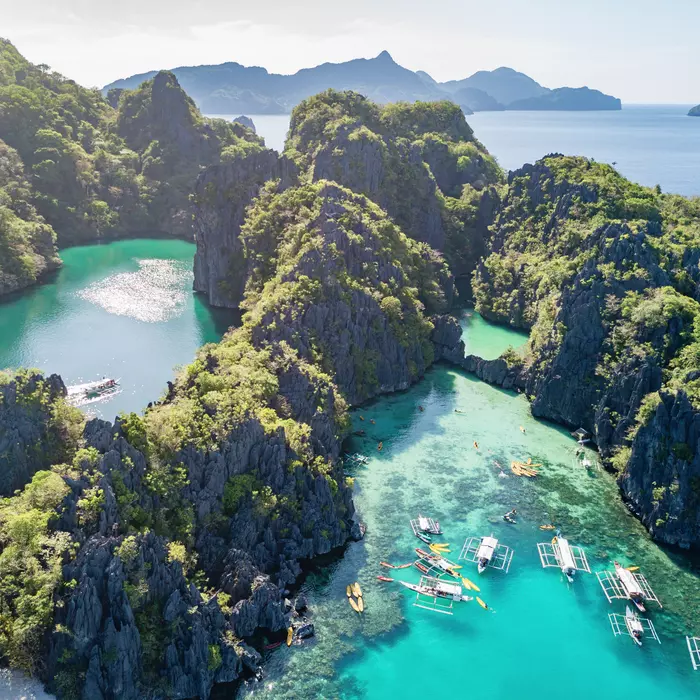 Big Lagoon and Small Logoon on Miniloc Island with filipino Balangay Tour Boats and Kayaks