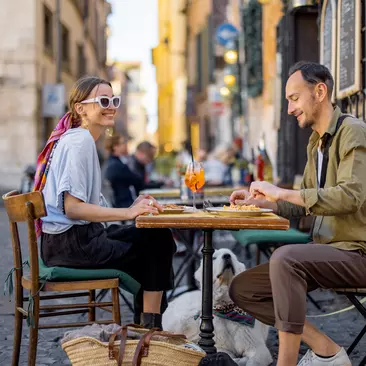 Woman eating italian pasta at restaurant on the street in Rome