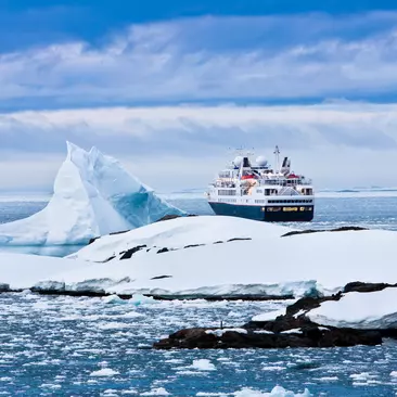 Overview of large cruise ship sailing through icy waters