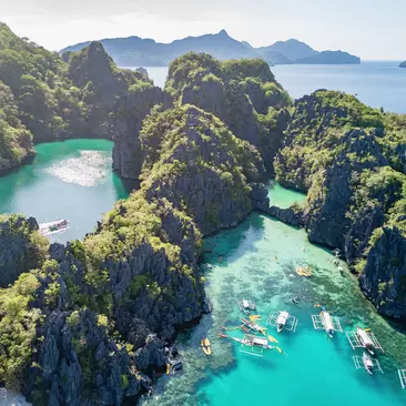Big Lagoon and Small Logoon on Miniloc Island with filipino Balangay Tour Boats and Kayaks
