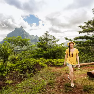 Brazilian woman on vacations on Morrea Island in French Polynesia. She is on top a volcanic landscape covered with tropical forest.