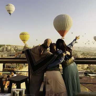Women holding up their hands watching the hot air balloons of Cappadocia, Turkiye