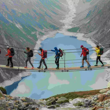A group of travellers walking across a suspension bridge above a fjord