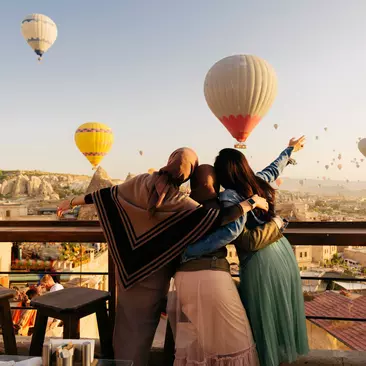 Women holding up their hands watching the hot air balloons of Cappadocia, Turkiye