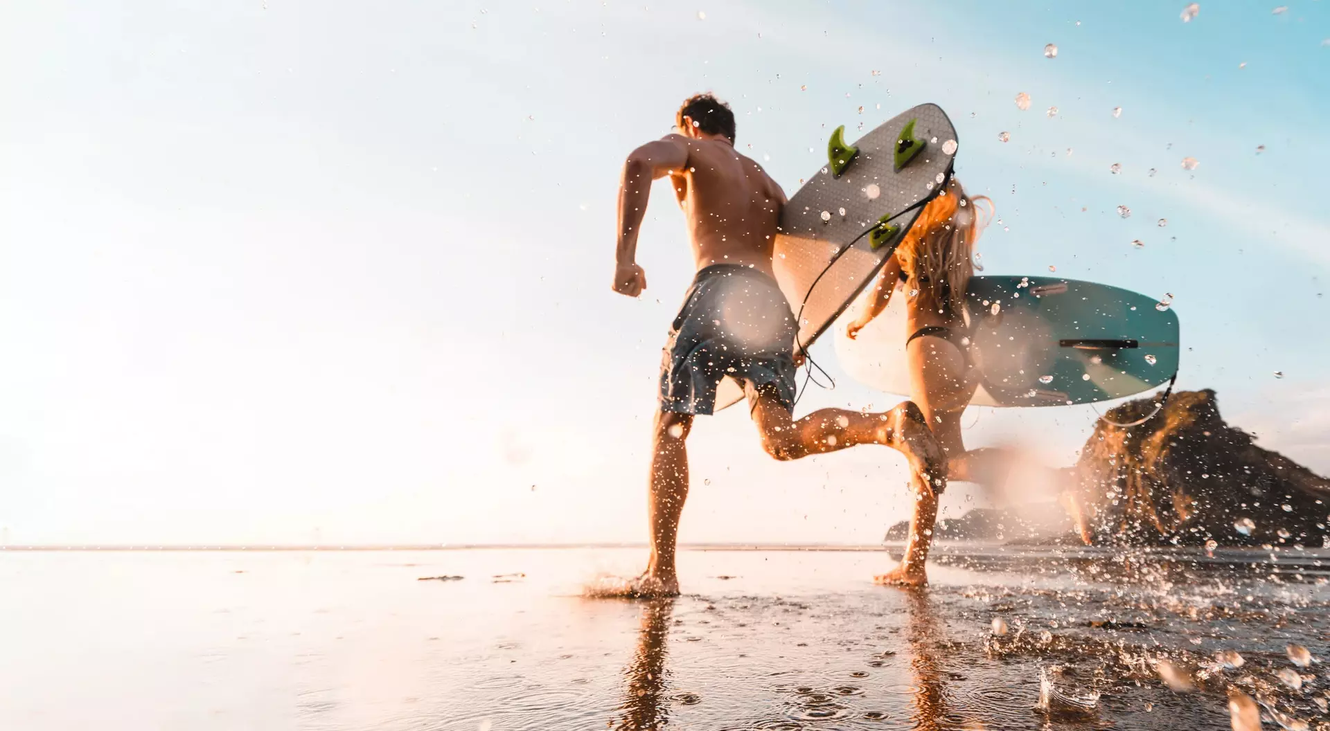 Piha Beach is renown for New Zealand's best surfing A couple surfing on Piha Beach, Auckland, New Zealand