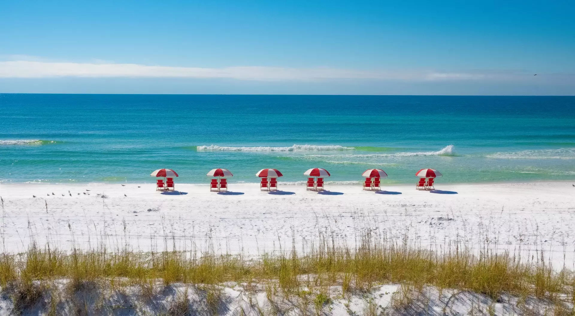Destin, Florida A row of chairs and umbrellas on a white sand beach.