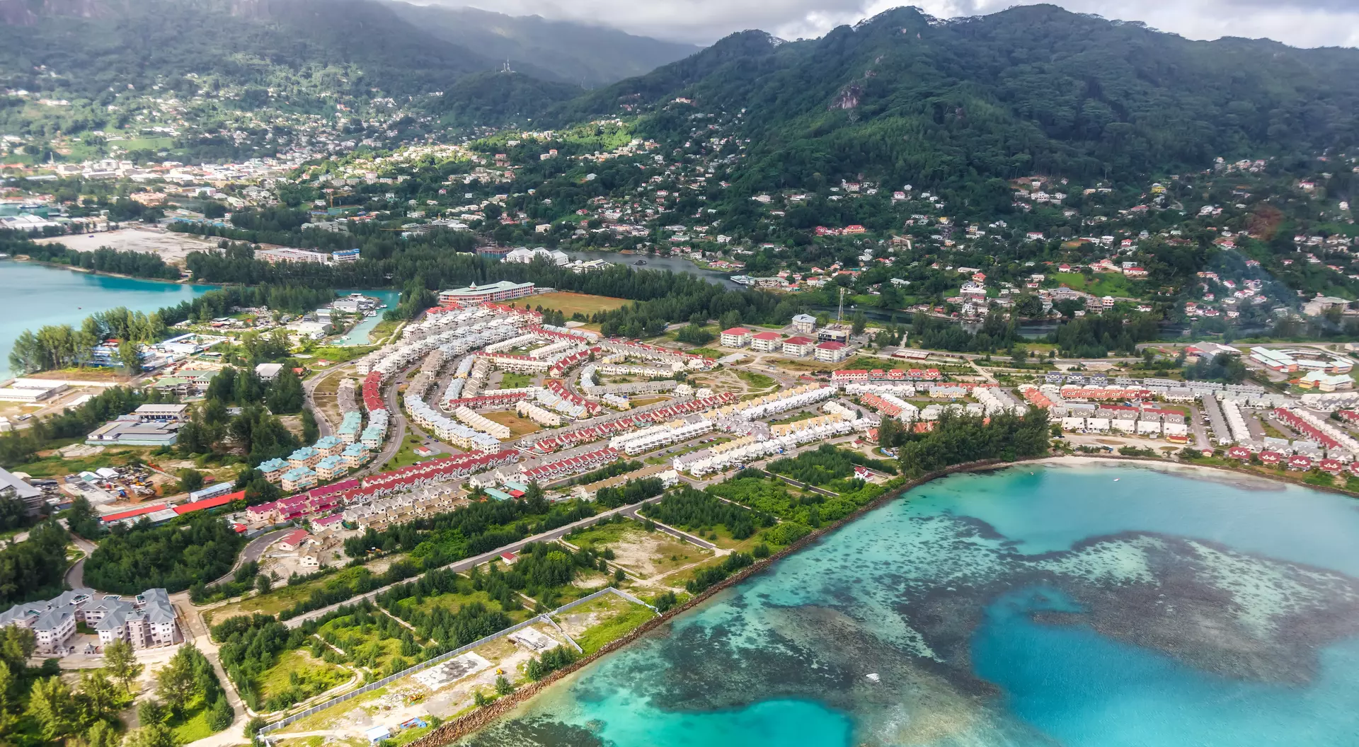 Aerial photo of neighbourhood, coastline and mountains in the background